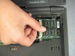 Installing memory upgrade board for an Apple Powerbook 1400c laptop.